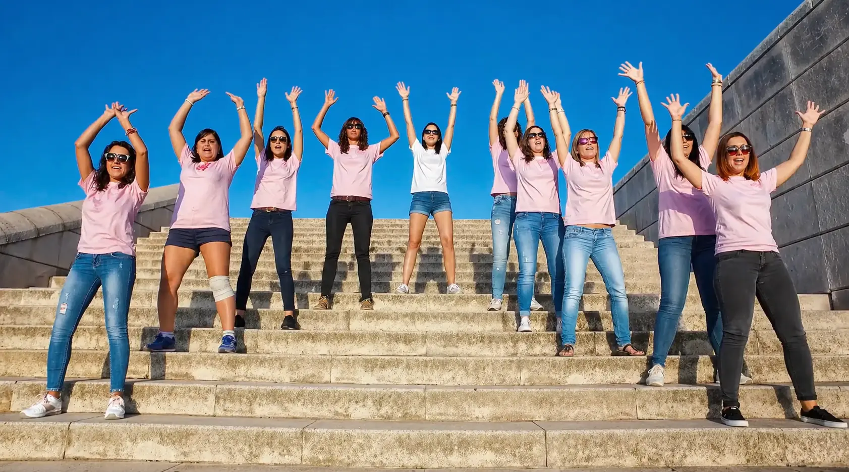 Participantes levantando los brazos durante la grabación de un lipdub de despedida